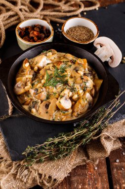 Krema soslu mantarlar, jülyen, şampiyon, ahşap bir masada şist siyah tahtada yemek pişirme ürünleri.