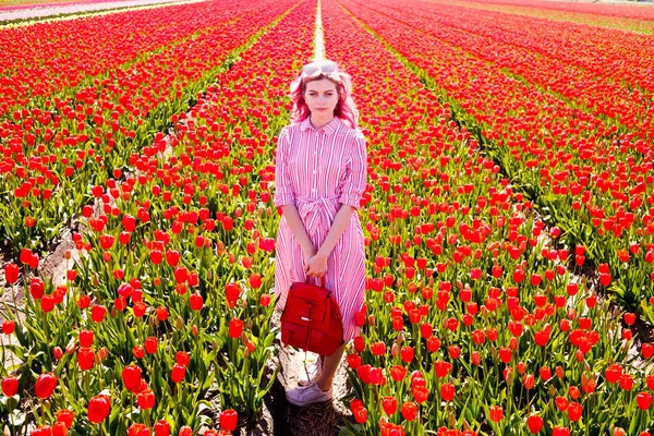 Sorrindo adolescente menina caminha através de campo de tulipa — Fotografia de Stock