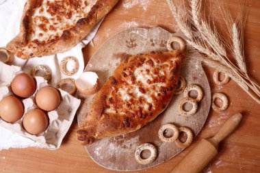 Geleneksel bir Ajarian khachapuri turtasının üst görüntüsü. Eritilmiş tuzlu suluguni peyniri ve yumurta sarısı ile birlikte açık bir turta. Geleneksel Gürcü mutfağı