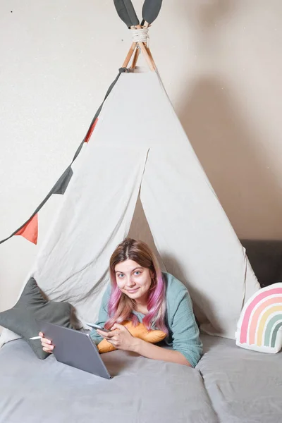 Uma Jovem Mãe Trabalha Computador Tablet Casa Uma Cabana Infantil — Fotografia de Stock