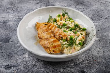 Sağlıklı öğle yemeği - kızarmış tavuk göğsü ve arka planda Olivier salatası