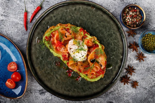 Sanduíche aberto com peixe vermelho salgado, ovo escalfado, vinagre balsâmico e micro-verduras. — Fotografia de Stock