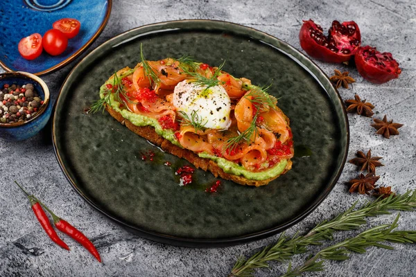 Sanduíche aberto com peixe vermelho salgado, ovo escalfado, vinagre balsâmico e micro-verduras. — Fotografia de Stock