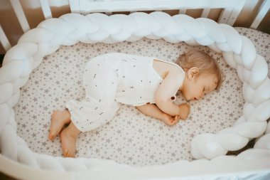 Yatakta uyuyan çekici bir çocuğun portresi, 1 yaşındaki çocuk konsepti.