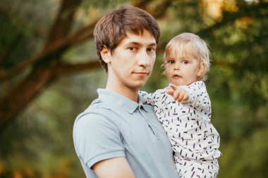 Mutlu aile babası ve oğlu parkta yürüyor.