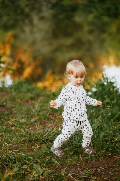 可爱的男孩穿着漂亮的白色西服 在大自然的背景下行走 大约一岁大的婴儿在户外学习和玩耍 — 图库照片