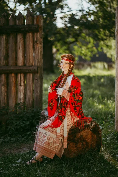 長いブロンドの髪と肩の上に白と赤の刺繍のスーツと赤のドレスで茶色の目を持つ美しいスラブの少女 ウクライナの地域の伝統的な服 夏の日 — ストック写真
