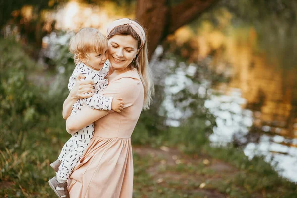 Uma Mãe Segura Seu Filho Seus Braços Dia Verão Parque — Fotografia de Stock