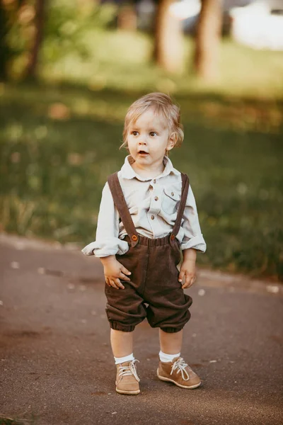 夏の日の日没時に畑でヴィンテージのジャンプスーツを着た小さなブロンドの男の子 — ストック写真