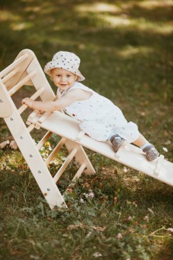 Çocuk spor kompleksinde çocuk kaydırağında spor yapıyor. 1,5 yaşında bebek jimnastik merdivenlerinden çıkıyor. Erken çocukluk gelişimi. Yaşam tarzı etkinliği