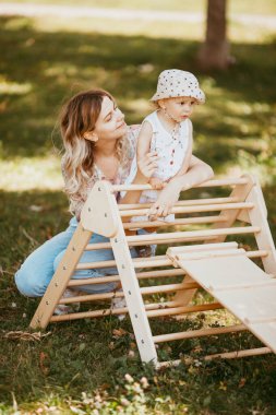 Annesinin yardımıyla bir spor kompleksinde jimnastik yapan sevimli bir çocuk. Çocuk sporları egzersizleri. Çocukların evde beden eğitimi