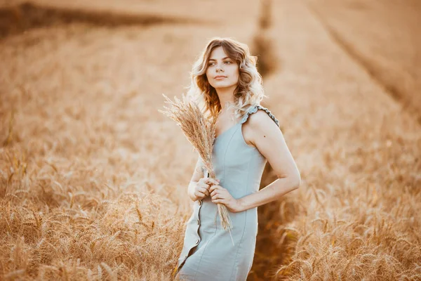 Młoda Dziewczyna Długimi Kręconymi Włosami Jasnoniebieską Sukienką Stojąca Polu Pszenicy — Zdjęcie stockowe