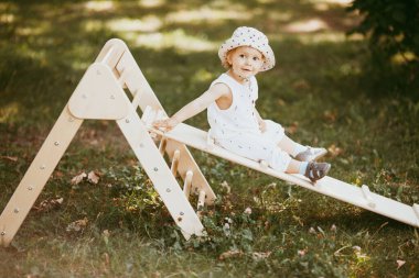 Çocuk spor kompleksinde çocuk kaydırağında spor yapıyor. 1,5 yaşında bebek jimnastik merdivenlerinden çıkıyor. Erken çocukluk gelişimi. Yaşam tarzı etkinliği