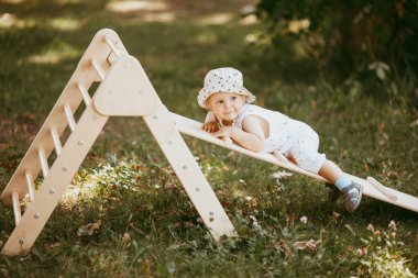 Çocuk sporu yapan çocuk spor kompleksinde kayıyor. 1,5 yaşında bebek jimnastik merdivenlerinden çıkıyor. Erken çocukluk gelişimi.