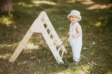 Çocuk sporu yapan çocuk spor kompleksinde kayıyor. 1,5 yaşında bebek jimnastik merdivenlerinden çıkıyor. Erken çocukluk gelişimi.