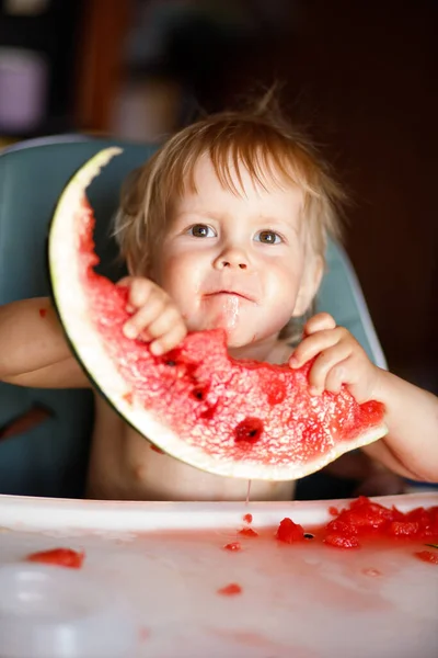 幸せな幼児男の子食べるスイカで彼の高い椅子 — ストック写真