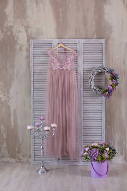 Stüdyo süsleme pembe ve bej renkli. Gümüş Aplik Pyres ayakta ahşap perde bej havadar şık elbise ile yakın ahşap zemin üzerinde.
