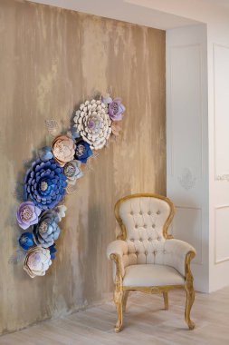 Rahat retro şık ev dekor tasarımcıları ve çiçekçi ruh royal renkleri ile ilham ile. eski moda mobilya sandalye Studio ateş arka plan kahverengi duvarda rahat kağıt çiçeklerle.