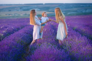 Sevimli oğlu ve lavanta zemin üzerine kız kardeşi ile mutlu anne. Bayan ve çocuk zevk aroma ve canlı renkler ile lavanta manzara. Renkli lavanta görünümünde aile fotoğrafı.