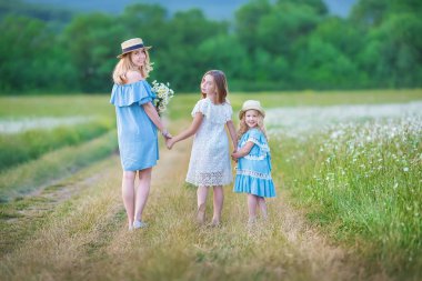 Mutlu anne ve kızı çocuk ile birlikte sarı Karahindiba çiçeği. yaz günü