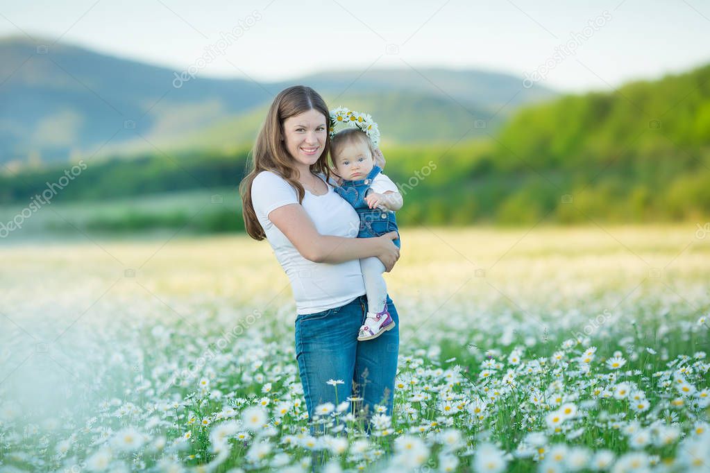 Young family in a field of flowers daises chamomile anjoy spa life happy together with cute faces in a village rustic motion.