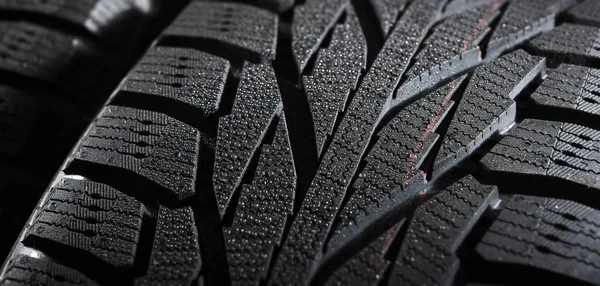 Brand new winter tires with a modern tread and water drops