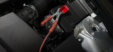 araba aküsü üzerinde kırmızı kelepçe. pil araba elektrikle şarj etmek için. 