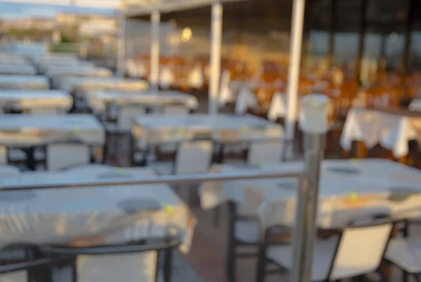 Blurred dining table restaurant with beautiful ocean view at twilight scene.