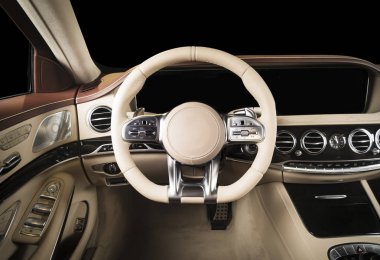 Modern lüks araba, direksiyon, vites kolu ve gösterge paneli. Araç içi lüks. Bej rahat koltuklar, direksiyon, gösterge paneli, hız göstergesi, ekran. Kırmızı ve beyaz delikli deri..