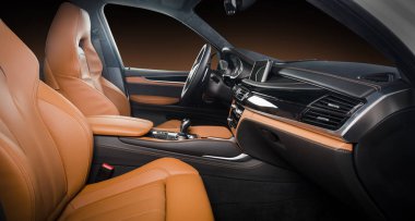 Modern lüks araba, direksiyon, vites kolu ve gösterge paneli. Arabanın içi lüks. Direksiyon, torpido, hız göstergesi, ekran. Kum turuncu kırmızı deri kokpit