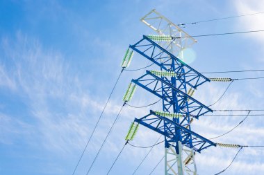 Mavi gökyüzüne ve bulutlara karşı yüksek voltajlı elektrik direkleri, elektrik hattı, elektrik direği.