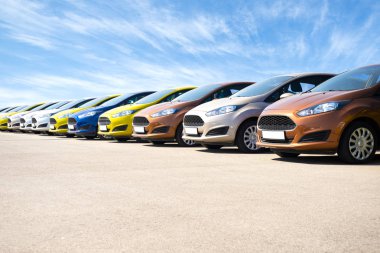 Riga, Letonya - 15 Mayıs 2018: Riga Letonya 'da gündoğumunda mavi gökyüzüne karşı satılık yeni arabalar.