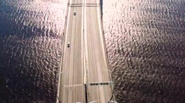 Köprüdeki otoban manzarası, hareket halindeki arabalar su yüzeyi manzarası üzerinde trafik yapıyor.