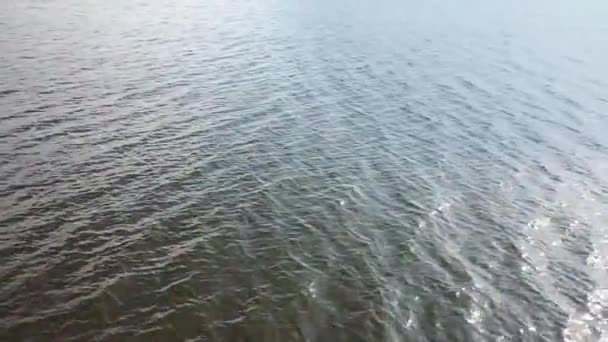 Vol à basse altitude au-dessus d'une surface d'eau sombre avec vagues