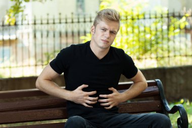 Parkta mide sorunları olan güzel bir kadının açık hava portresi.