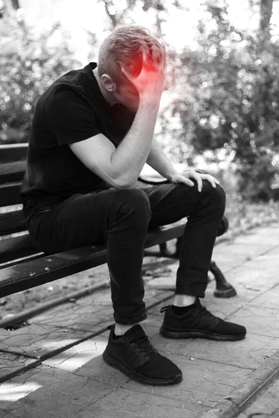 公園で片頭痛の痛みを持つストレスと頭痛のあるきれいな男の肖像画 赤のアクセントを持つ黒と白 — ストック写真