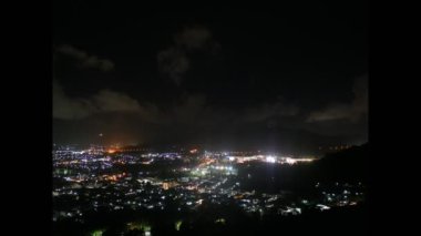 Yüksek dağ Güneş battıktan sonra alacakaranlık mavi gökyüzü akşam üzerinde hareketli bulut Timelapse. Bina şehir şehir ve parlak road arabaya ışıklar. Manzaraya tepenin basamak Hill bakış açısı veya Khao basamak Phuket