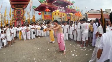 Phuket, Tayland - 8 Ekim 2018 - Çin Tanrısı ruhani medyumu, Juitui Tapınağı 'nda başlayan vejetaryen festivalinin sembolü olan kutsal bambu ağaç direğini kaldırma gününde bedenine ateş saplayarak tütsüyü aldı.