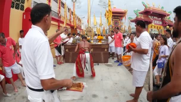 Phuket Thailand - 8. Oktober 2018 - Menschen legen dünnen goldenen Teller an die heilige Bambusholzstange und erheben sich, ist das Symbol des beginnenden 9-tägigen Phuket Vegetarian Festival am Juitui Shrine.