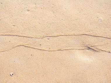 Sahildeki kum zeminini kapatın, arka planda ve desenli