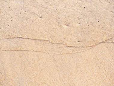 Sahildeki kum zeminini kapatın, arka planda ve desenli