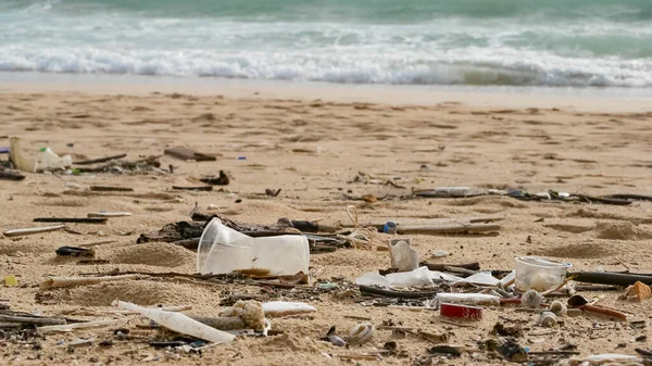 Environmental pollution. Ecological problem. Garbages, plastic, and wastes on the sandy beach of tropical sea.