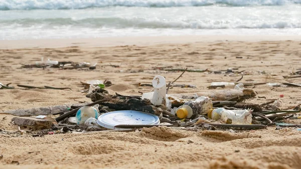 Environmental pollution. Ecological problem. Garbages, plastic, and wastes on the sandy beach of tropical sea.