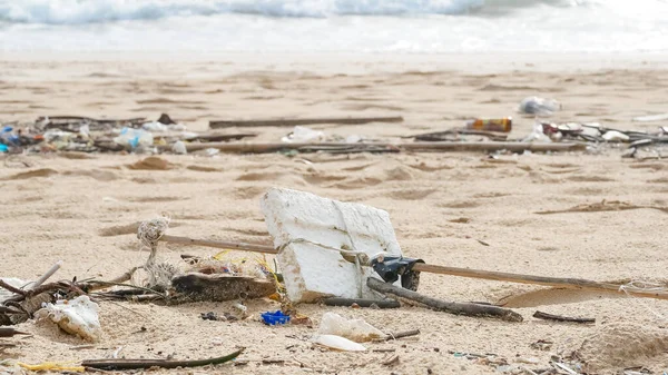 Environmental pollution. Ecological problem. Garbages, plastic, and wastes on the sandy beach of tropical sea.