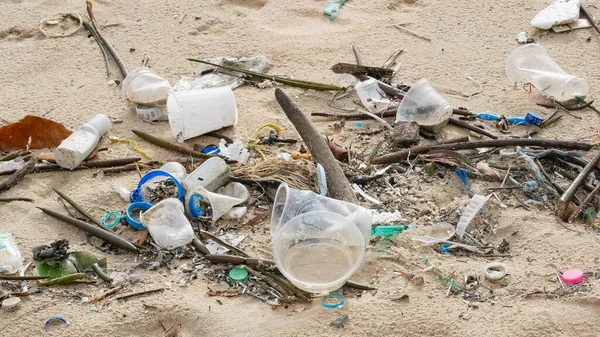 Environmental pollution. Ecological problem. Garbages, plastic, and wastes on the sandy beach of tropical sea.