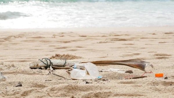 Environmental pollution. Ecological problem. Garbages, plastic, and wastes on the sandy beach of tropical sea.