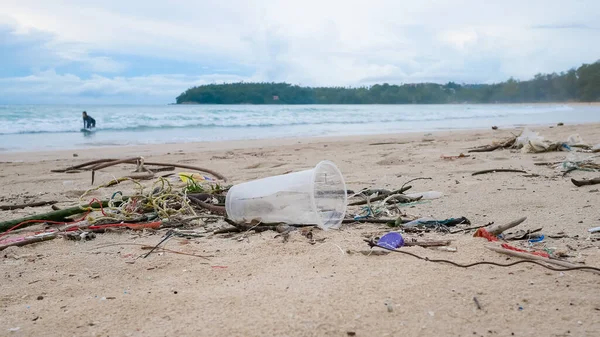 Environmental pollution. Ecological problem. Garbages, plastic, and wastes on the sandy beach of tropical sea.