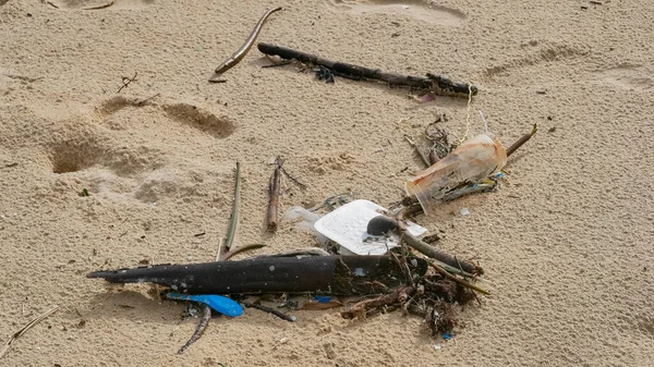 Environmental pollution. Ecological problem. Garbages, plastic, and wastes on the sandy beach of tropical sea.