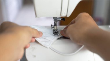 Kumaş ve iplikli elektrikli dikiş makinesi, koruyucu maske üzerindeki odaklanma azalması, COVID-19 salgını sırasında antivirüs maskesi.