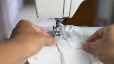 Kumaş ve iplikli elektrikli dikiş makinesi, koruyucu maske üzerindeki odaklanma azalması, COVID-19 salgını sırasında antivirüs maskesi.